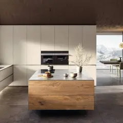 Elegante cucina bianca e legno naturale con isola centrale. Ampia finestra con vista panoramica sulle montagne.
