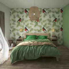 Camera da letto con carta da parati a tema uccelli e pigne. Lenzuola verde oliva e coperta color sabbia. Tende bianche svolazzanti.