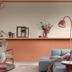 Soggiorno con pareti color pesca e beige, un divano grigio e una poltrona vintage. Idee pareti colorate particolari per un ambiente accogliente.