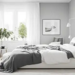 Camera da letto in stile minimalista, con letto bianco, coperte grigie e piante verdi. Un'oasi di pace che rispetta i principi del feng shui.