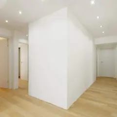 Un moderno ingresso con un divisorio in cartongesso che crea un'elegante separazione. Le idee per l'ingresso sono valorizzate dal design pulito e dai pavimenti in legno chiaro.