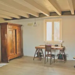 Interni di le più belle case di campagna: armadio antico, specchio, scrivania rustica e tavolino rotondo con lampada Torre Eiffel.