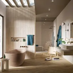 Bagno moderno con vasca freestanding, doccia a vista e lavabo sospeso. Le pareti sono rivestite con piastrelle che creano un effetto materico, quasi come se si stesse incollare piastrelle su piastrelle bagno.