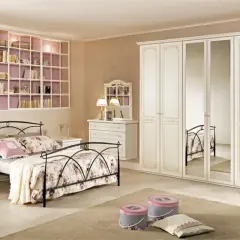 Camera da letto classica: letto in ferro battuto, armadio bianco con specchi, cassettiera e libreria a muro.