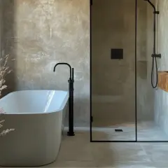 Bagno moderno con vasca freestanding, doccia walk-in e lavabo in legno grezzo. Pareti effetto resina e dettagli neri.