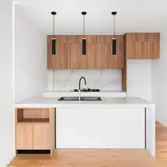Cucine piccole particolari con isola bianca, pensili in legno e tre lampade nere sospese.
