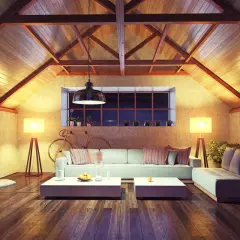 Accogliente soggiorno mansardato con travi a vista e illuminazione calda. Ottime idee sottotetto molto basso per creare un ambiente confortevole.