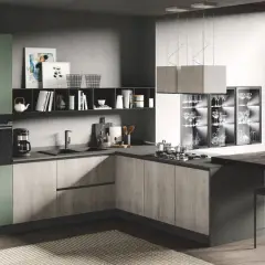 Elegante cucina due colori con ante verdi e finitura legno, isola con sgabelli e vista su un giardino lussureggiante.