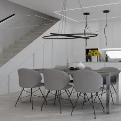 Un tavolo con sedie grigie in una moderna cucina bianca, con scala a vista e illuminazione minimalista. Perfette idee cucina bianca per un ambiente luminoso.