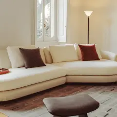 Soggiorno accogliente con divano bianco, cuscini colorati e vassoio. Un esempio di come fare decluttering per un ambiente sereno.