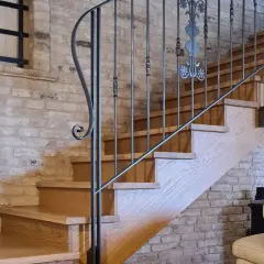 Scale interne in legno con ringhiera in ferro battuto, un'idea di design che unisce rustico e moderno.