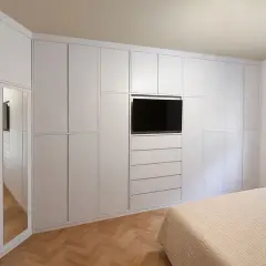 Armadio a muro bianco con TV integrata e specchio, perfetto per idee armadio camera da letto piccola.