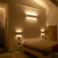 Moderne idee illuminazione led soggiorno: applique a parete creano un'atmosfera calda e accogliente attorno al letto.