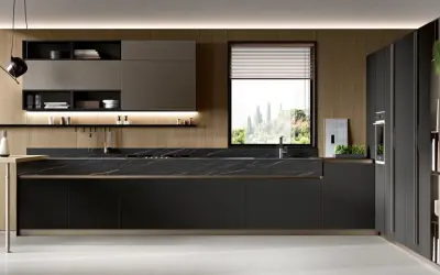 Cucina moderna con pensili in legno, piano in marmo nero e una grande finestra che si affaccia su un paesaggio verdeggiante.