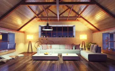 Accogliente soggiorno mansardato con travi a vista e illuminazione calda. Ottime idee sottotetto molto basso per creare un ambiente confortevole.