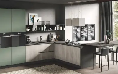 Elegante cucina due colori con ante verdi e finitura legno, isola con sgabelli e vista su un giardino lussureggiante.