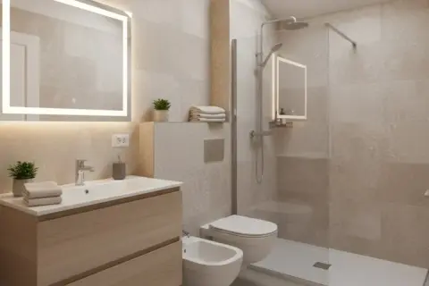 Bagno moderno con lavabo, bidet e doccia. Un secondo bagno piccolissimo, ma funzionale, con specchio illuminato e finiture in legno chiaro.