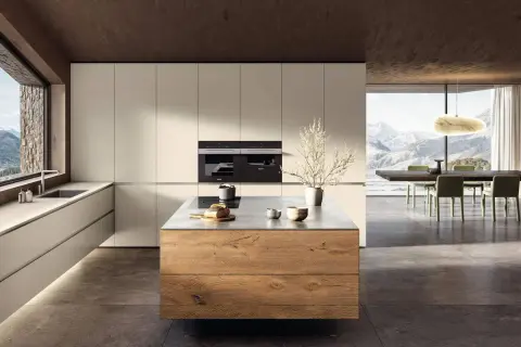 Elegante cucina bianca e legno naturale con isola centrale. Ampia finestra con vista panoramica sulle montagne.
