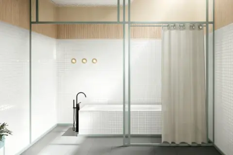 Bagno moderno con vasca e rubinetto a colonna. Una tenda color crema offre un'alternativa alla tenda doccia, separando la zona.