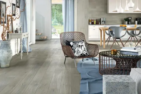 Soggiorno e cucina moderni con pavimento grigio chiaro, mobili di design e un'ampia vetrata sul giardino.