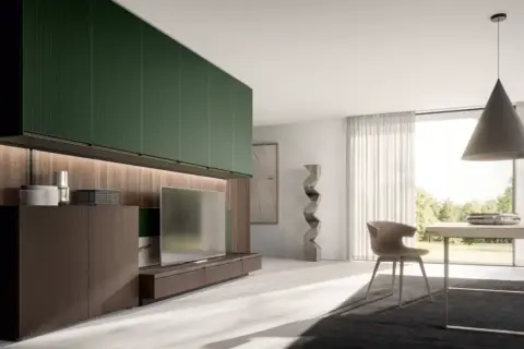 Soggiorno moderno con pensili verde foresta, mobile TV in legno scuro, scultura astratta e tavolo da pranzo con vista sul giardino.