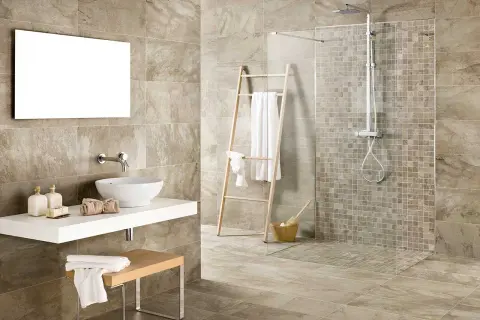Bagno moderno con doccia senza piatto, lavabo a ciotola e specchio rettangolare. Asciugamani bianchi su scala di legno.