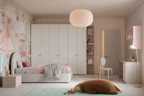 Camera ragazza aesthetic con carta da parati circense, letto rosa, armadio bianco e un peluche a forma di orso sul tappeto stellato.