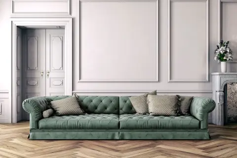 Divano verde bosco con cuscini beige, abbinamenti eleganti in un salotto classico con parquet.
