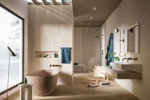 Bagno moderno con vasca freestanding, doccia a vista e lavabo sospeso. Le pareti sono rivestite con piastrelle che creano un effetto materico, quasi come se si stesse incollare piastrelle su piastrelle bagno.