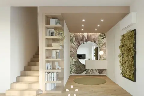 Ingresso casa con libreria in legno, specchio rotondo su carta da parati tropicale e parete verde. Idee d'arredo moderne e accoglienti.