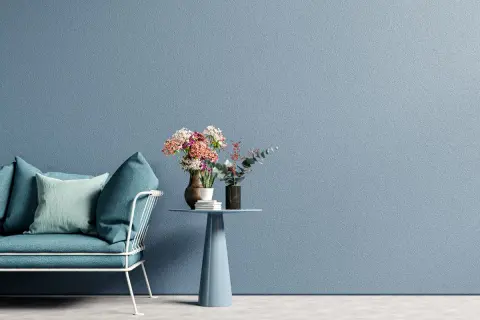 Divano turchese e tavolino con fiori su sfondo blu polvere, un'ispirazione per una moderno pittura cameretta.
