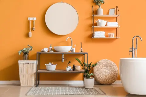 Bagno moderno con pareti arancioni vivaci, lavabo sospeso, vasca bianca e idee pittura bagno che ispirano freschezza e stile.