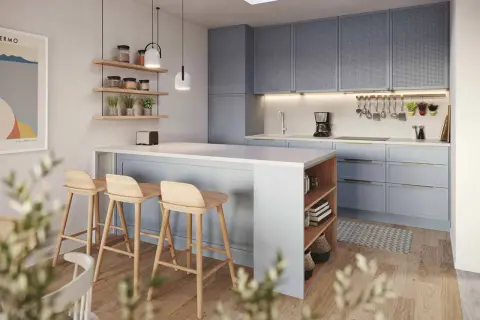 Accogliente piccola cucina con isola a muro, sgabelli in legno e pensili azzurri.