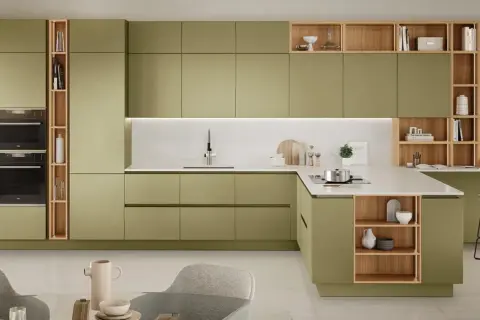 Elegante cucina verde e legno con isola, pensili a giorno e zona studio integrata.