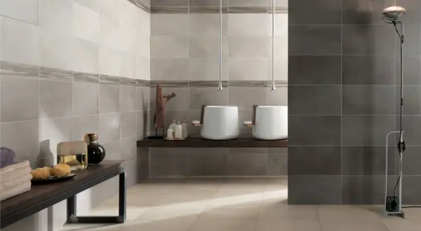 Moderne idee bagno con gres porcellanato effetto pietra. Due lavabi sospesi, un mobile con profumi e asciugamani.