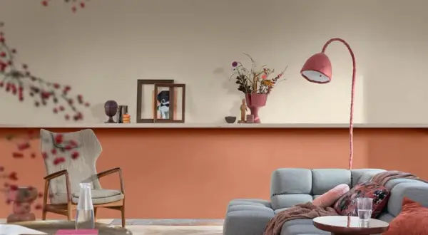 Soggiorno con pareti color pesca e beige, un divano grigio e una poltrona vintage. Idee pareti colorate particolari per un ambiente accogliente.