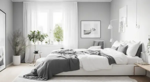 Camera da letto in stile minimalista, con letto bianco, coperte grigie e piante verdi. Un'oasi di pace che rispetta i principi del feng shui.