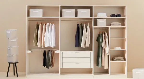 Un armadio bianco ben organizzato con vestiti appesi, scatole contenitive e cassetti.
