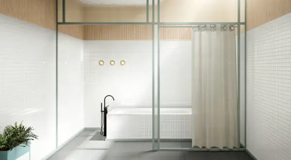 Bagno moderno con vasca e rubinetto a colonna. Una tenda color crema offre un'alternativa alla tenda doccia, separando la zona.