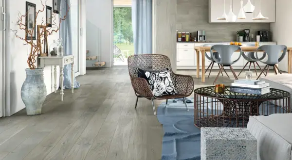 Soggiorno e cucina moderni con pavimento grigio chiaro, mobili di design e un'ampia vetrata sul giardino.