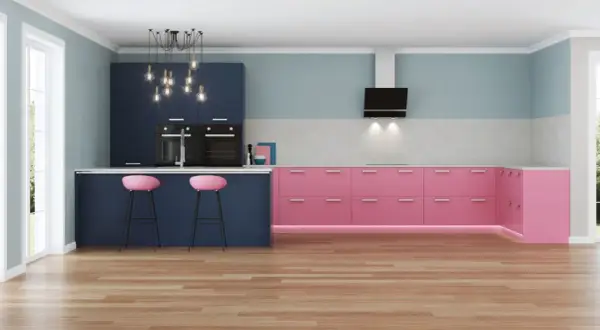 Moderna cucina con pensili blu scuro e basi rosa acceso. Due sgabelli rosa completano l'isola.