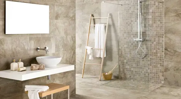 Bagno moderno con doccia senza piatto, lavabo a ciotola e specchio rettangolare. Asciugamani bianchi su scala di legno.