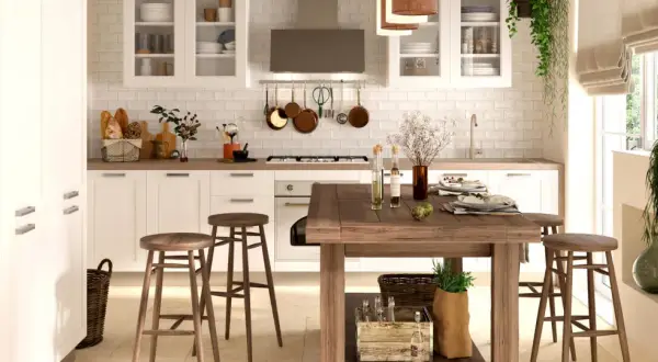 Cucina luminosa con pavimento in cotto, mobili bianchi, isola in legno e dettagli rustici. Perfetti abbinamenti cucine con pavimento in cotto per un ambiente caldo.