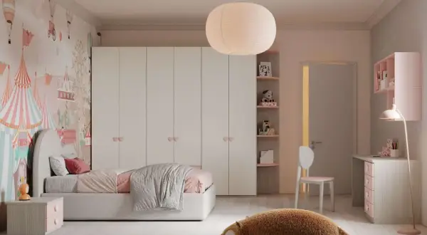Camera ragazza aesthetic con carta da parati circense, letto rosa, armadio bianco e un peluche a forma di orso sul tappeto stellato.