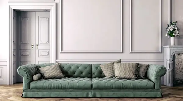 Divano verde bosco con cuscini beige, abbinamenti eleganti in un salotto classico con parquet.