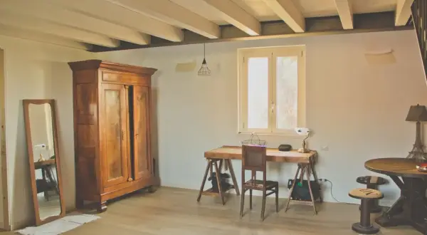 Interni di le più belle case di campagna: armadio antico, specchio, scrivania rustica e tavolino rotondo con lampada Torre Eiffel.