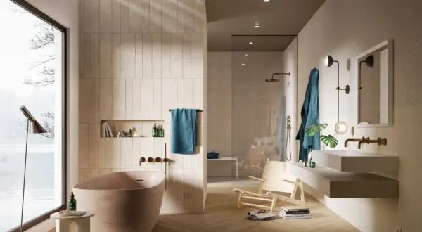 Bagno moderno con vasca freestanding, doccia a vista e lavabo sospeso. Le pareti sono rivestite con piastrelle che creano un effetto materico, quasi come se si stesse incollare piastrelle su piastrelle bagno.