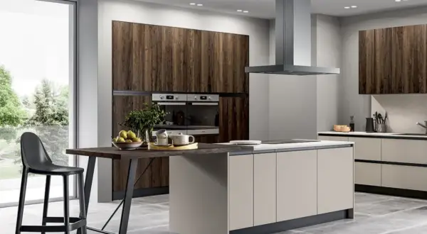 Elegante cucina grigio e legno con isola centrale, bancone snack e vista sul verde.