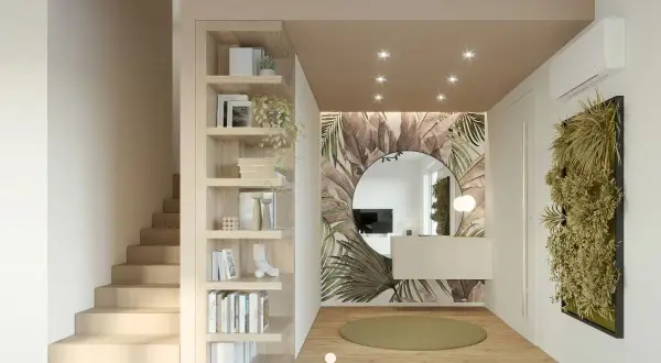 Ingresso casa con libreria in legno, specchio rotondo su carta da parati tropicale e parete verde. Idee d'arredo moderne e accoglienti.