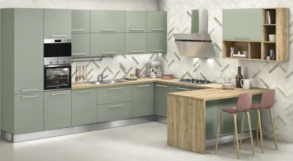 Elegante cucina verde malva con isola in legno, elettrodomestici in acciaio e sgabelli rosa.